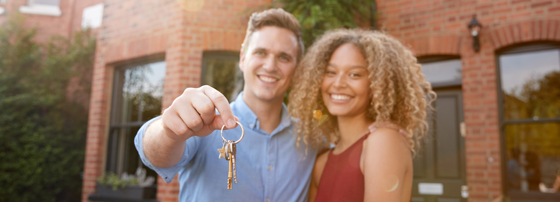 Couple standing outside a house with the keys